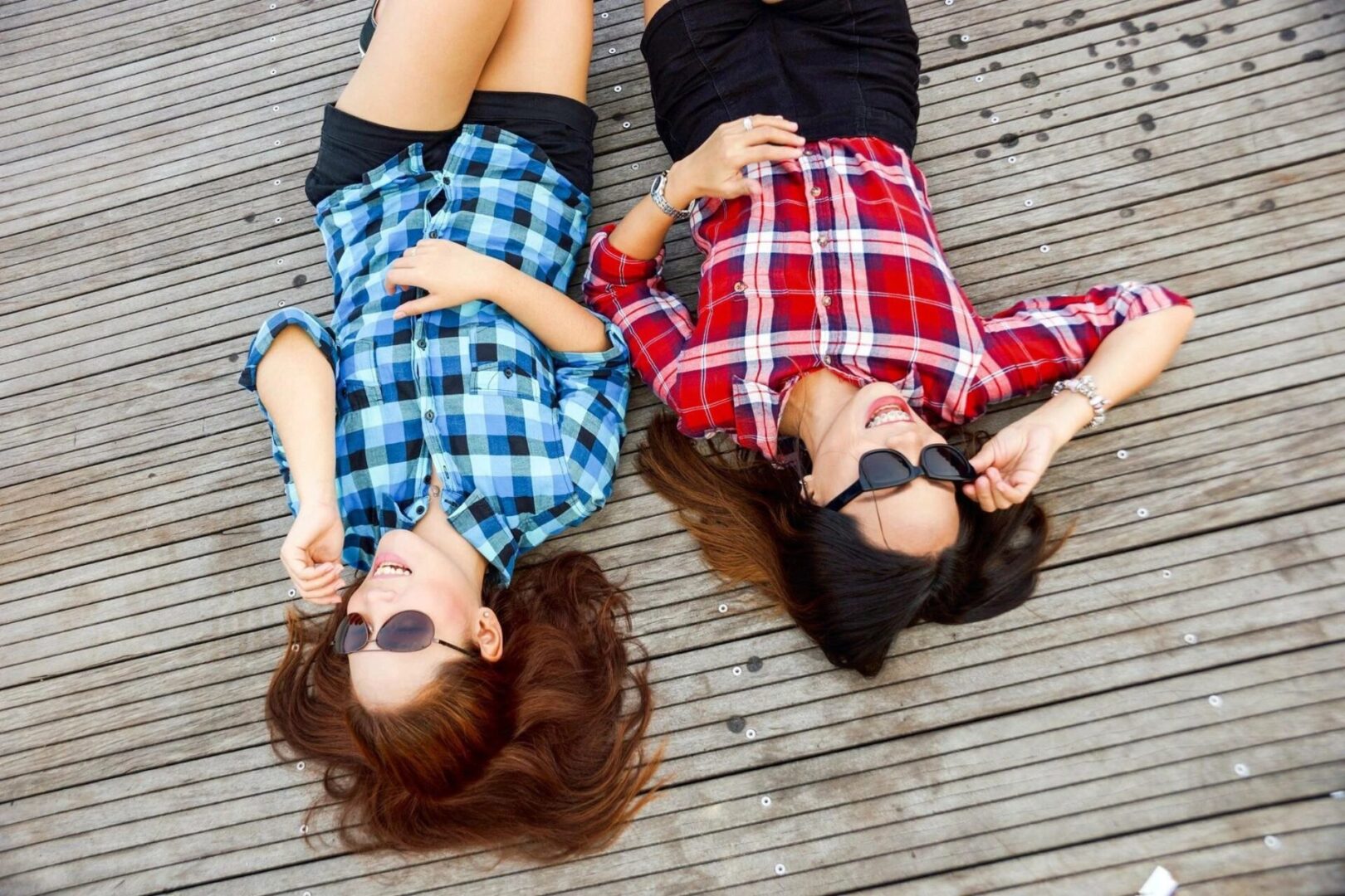 Two young woman sleeping on the wooden deck