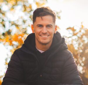 Mark Harrison Photo Cropped A man in black jacket smiling for the camera.